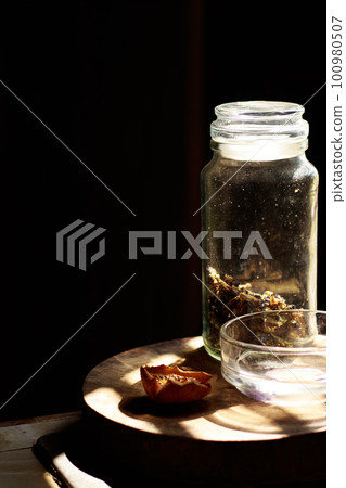 Light and shadow cast on a jar of dried Clitoria ternatea or asian pidgeonwing flowers for making healthy herbal tea Light and shadow cast on a jar of dried Clitoria ternatea or asian pidgeonwing flowers for making healthy herbal tea 100980507