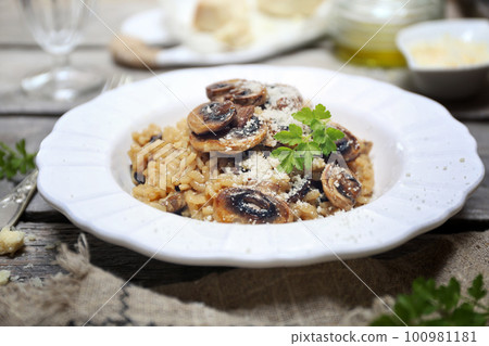 Italian food. Mushroom risotto, olive oil and grated parmesan cheese gressing 100981181