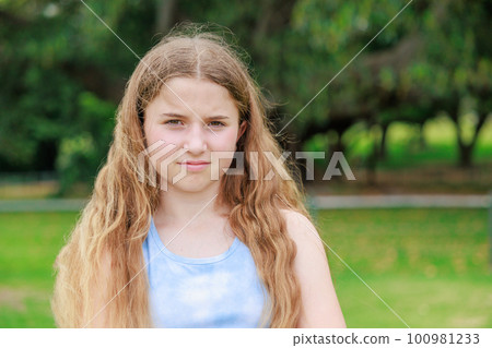 Australian girl getting angry at the camera in a green park Australian girl getting angry at the camera in a green park 100981233