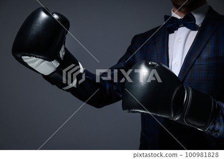 Businessman in boxing gloves on dark gray background 100981828