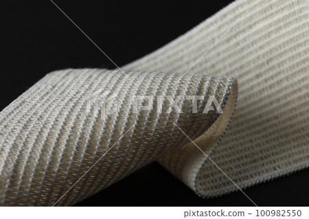 Elastic bandage on black background, close up Elastic bandage on black background, close up 100982550