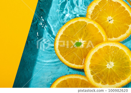 Orange slices in water, two tone background 100982620
