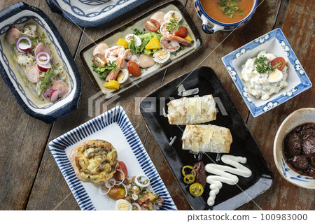 selection of many different tapas on rustic wood table 100983000