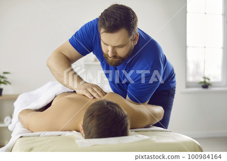 Man masseur do manual massage to male client Man masseur do manual massage to male client 100984164
