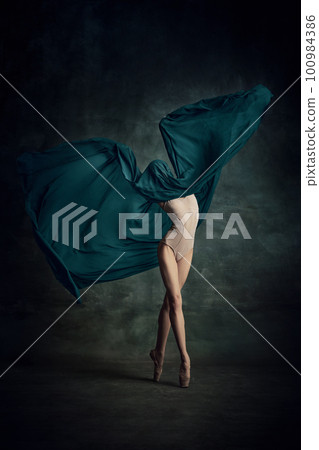 Shot of tender professional ballerina dancing in beige bodysuit with fabric isolated over dark green background Shot of tender professional ballerina dancing in beige bodysuit with fabric isolated over dark green background 100984386