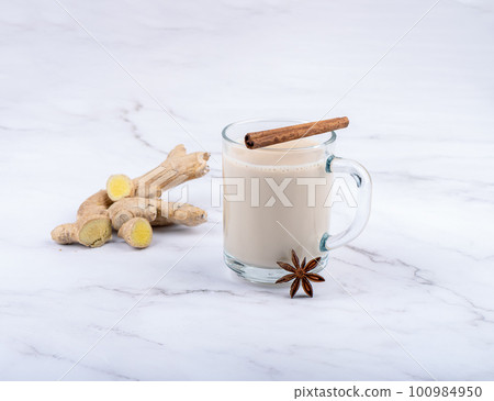 Glass mug with masala chai, ginger root, cinnamon and anise. Glass mug with masala chai, ginger root, cinnamon and anise. 100984950