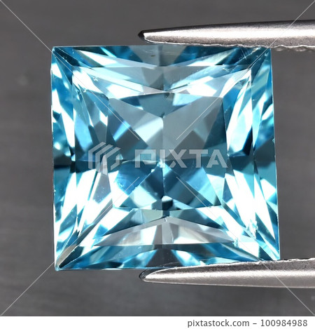 Natural blue topaz gemstone on gray background Natural blue topaz gemstone on gray background 100984988