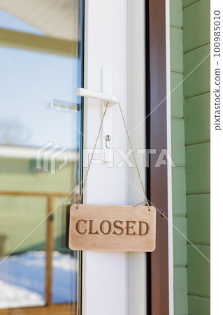 wooden sign is closed on door of restaurant or store. inscription with mode of operation wooden sign is closed on door of restaurant or store. inscription with mode of operation 100985010