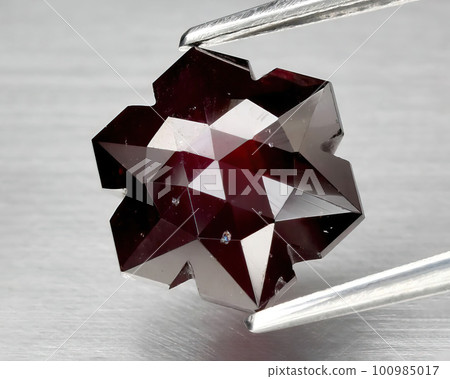 Natural gemstone red rhodolite garnet on gray background Natural gemstone red rhodolite garnet on gray background 100985017