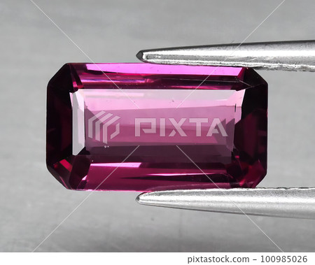 Natural gemstone red rhodolite garnet on gray background Natural gemstone red rhodolite garnet on gray background 100985026