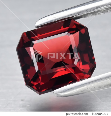 Natural gemstone red rhodolite garnet on gray background Natural gemstone red rhodolite garnet on gray background 100985027