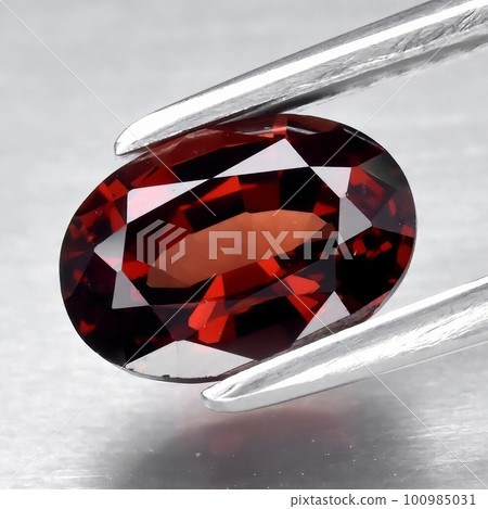 Natural gemstone red rhodolite garnet on gray background 100985031