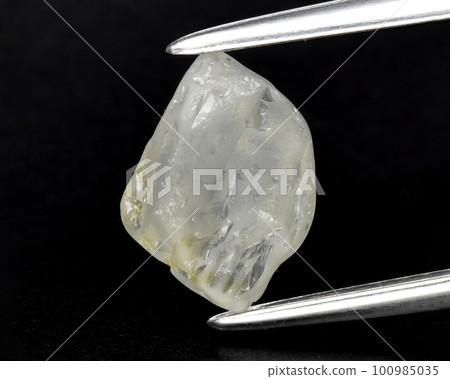 Natural gemstone yellow sapphire on a gray background. Raw sapphire crystal Natural gemstone yellow sapphire on a gray background. Raw sapphire crystal 100985035