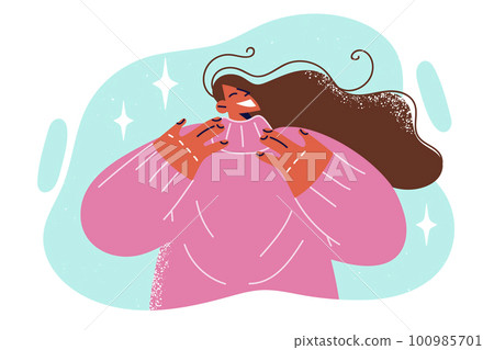 Positive woman smiles as she tries on warm sweater necessary for winter unheated rooms Positive woman smiles as she tries on warm sweater necessary for winter unheated rooms 100985701