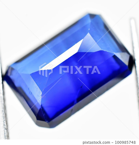 Natural gemstone blue sapphire on gray background 100985748