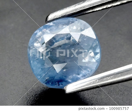 Natural gemstone blue sapphire on gray background 100985757