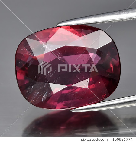 Natural gemstone red ruby on gray background 100985774
