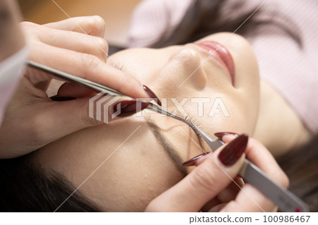 A woman receiving eyelash extensions (photographed by Makanani) 100986467