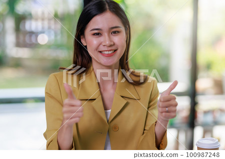 Concept of business office woman working,Businesswoman smile while thumb up after finish analyzing invesment plan document and business investment graph data by using laptop on desk in workstation. Concept of business office woman working,Businesswoman smile while thumb up after finish analyzing invesment plan document and business investment graph data by using laptop on desk in workstation. 100987248