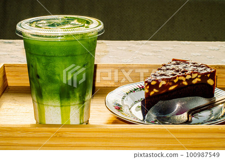 bownie cake on flower pattern vintage plate serve with and Green tea Latte 100987549