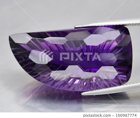 Natural gemstone purple amethyst on gray background 100987774