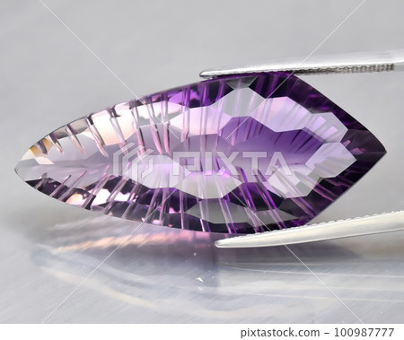 Natural gemstone purple amethyst on gray background 100987777