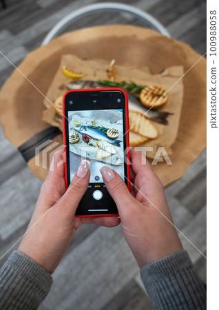 Woman takes food photo Woman takes food photo 100988058