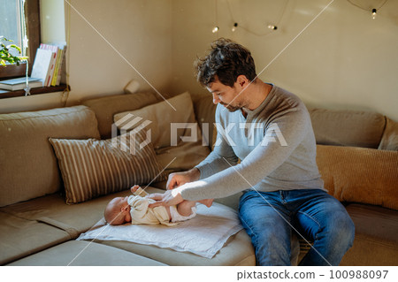 Mature father changing diaper his newborn son. 100988097