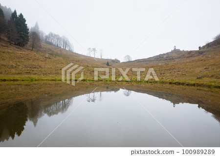 Foggy landscape from Asiago plateau trekking path Foggy landscape from Asiago plateau trekking path 100989289