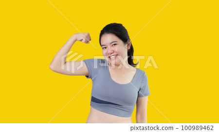 Woman flexing her muscles, Young Asian woman shows off her strength by flexing her jaw and showing off her power, Healthy, Happiness of your choice, White background. Woman flexing her muscles, Young Asian woman shows off her strength by flexing her jaw and showing off her power, Healthy, Happiness of your choice, White background. 100989462