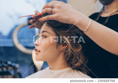 在美容院做頭髮和化妝的女人 在美容院做頭髮和化妝的女人 100989766