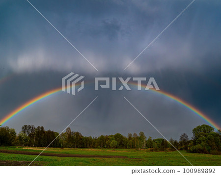 Rainbow with rain clouds in the sky. Rainbow with rain clouds in the sky. 100989892
