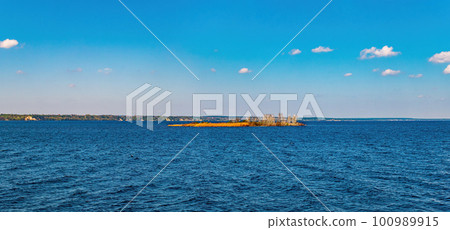 Small island on the sea horizon against the background of the sky. 100989915