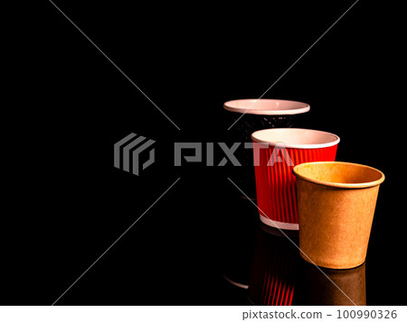 Disposable cardboard coffee cups on a black background. 100990326