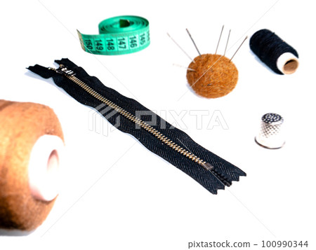 Knitted zipper and sewing accessories on a white background. 100990344