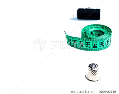 Tailor centimeter and sewing accessories on a white background. 100990346