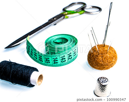 Measuring meter and sewing accessories on a white background. 100990347