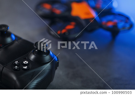 A reconnaissance quadcopter drone with an orange body a 100990503