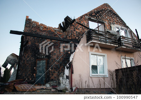 Destroyed building after russian invasion, Ukraine. Ruined facade of house. War in Ukraine. Broken windows and brick walls after missile attack. Abandoned damaged home. War disaster. 100990547