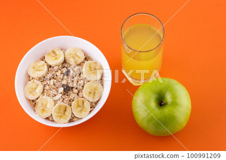 oatmeal juice and apple on orange background 100991209