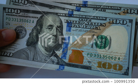 A lot of hundred-dollar bills in a woman's hand 100991350
