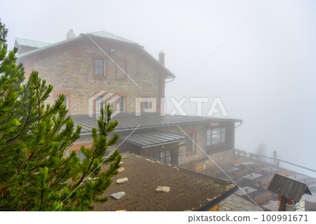 The mountain shelter of Jiri's House, Czech: Chata Jiriho, on Serak shrouded in fog. A tourist cabin on one of the highest peaks of Hruby Jesenik, Czech Republic 100991671