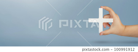 Symbol white plus or cross in hand. The concept of social security, and health insurance. Benefits, personal development, growth concept. Mathematical symbol plus white in hand on a blue background 100991912