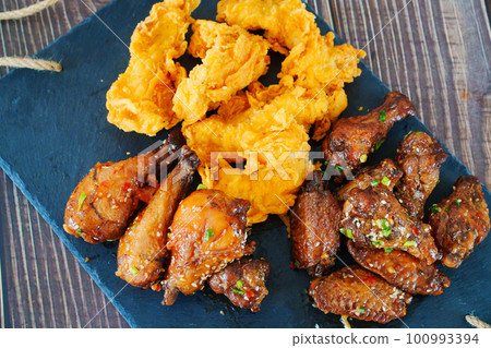 caramelized chicken with sesame and garlic, meat strips in breadin. caramelized chicken with sesame and garlic, meat strips in breadin. 100993394