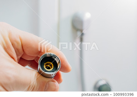 men's hands with the shower hose in the shower cabin. men's hands with the shower hose in the shower cabin. 100993396