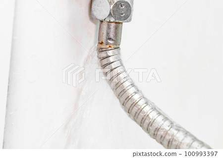 water is flowing from a broken shower hose. water is flowing from a broken shower hose. 100993397