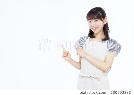 一位三十多歲的家庭主婦穿著圍裙指著她的手指 一位三十多歲的家庭主婦穿著圍裙指著她的手指 100993888