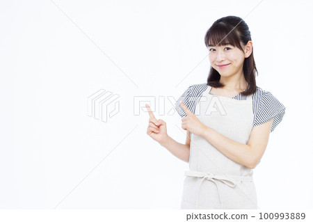 A housewife in her thirties wearing an apron pointing her finger 100993889