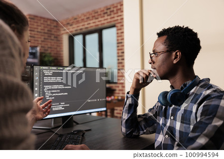 Diverse tech enginners developing machine learning algorithm in order to sustain system security stability. Software developer creating network using binary encryption in it agency office. 100994594