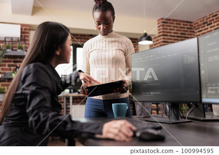 Team of software developers debugging algorithm working in it developing agency. Programming engineers analyzing source code on computer monitor, comparing data script in busy agency office. 100994595